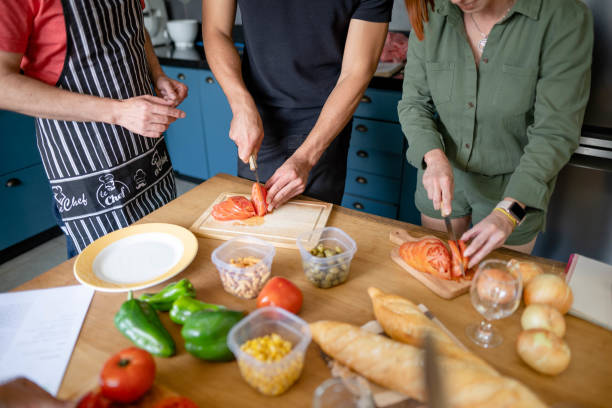 istock Adult students chopping vegetables during a cooking class with a teacher 1480663501