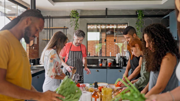 istock Teacher watching students chopping tomatoes in a cooking class 1480663524