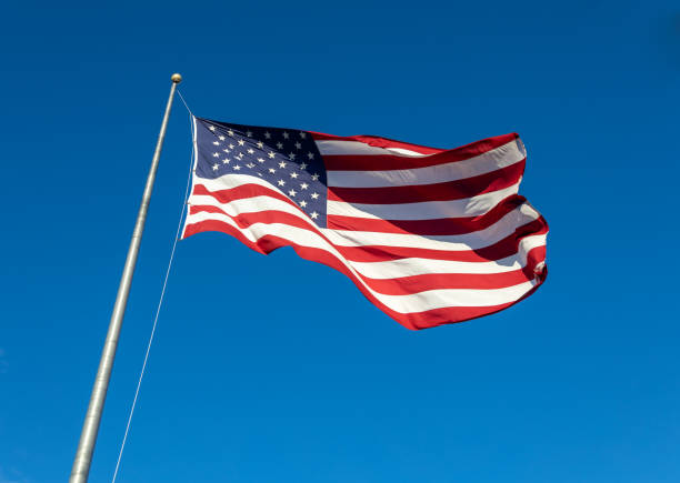 istock American flag on flagpole with blue sky 1480663604