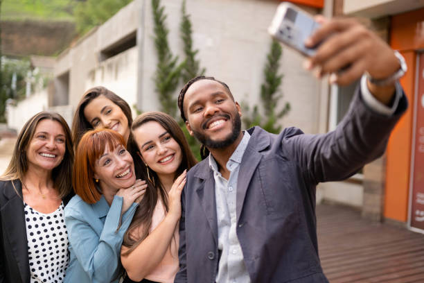 istock Friends smiling and taking selfies together outside on a patio 1480667718