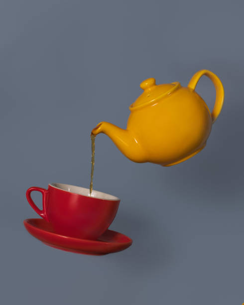 A flying yellow teapot pouring tea to a red cup