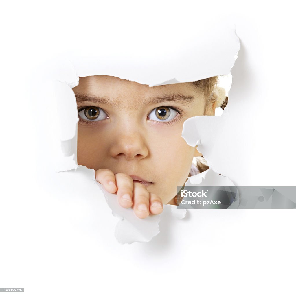 Child's face looking through a hole in paper Face of the child looking through a hole in the white paper Baby Girls Stock Photo