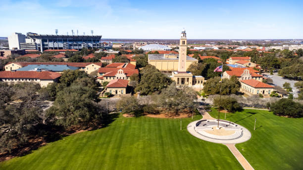 Memorial Tower on LSU campus is a memorial to Louisianans who died in World War I, with Tiger Stadium and the Pete Maravich Assembly center in the background. stock photo