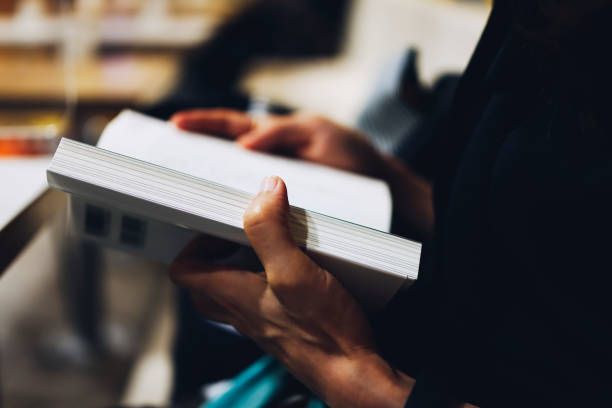 istock hands of a person reading a book 1480680662