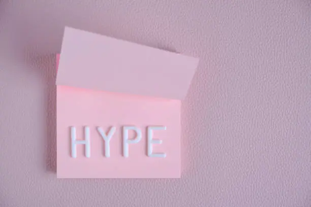 Photo of Word hype laid out white letters pink piece paper.Concept hype, popularity and fun.