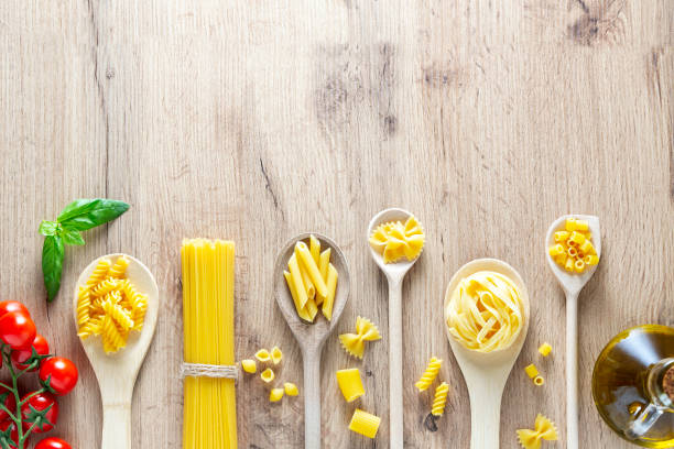 istock Various pasta in spoons, tomatoes, basil and olive oil. Top view flat lay 1480690844