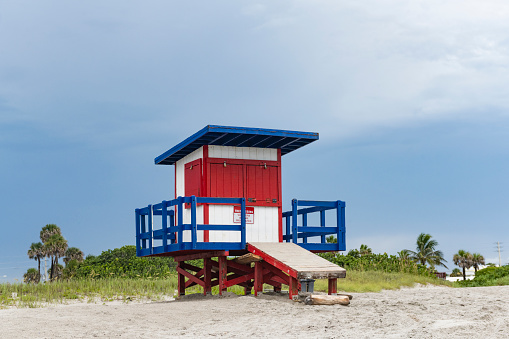 This is a photograph of a closed wooden lifeguard hut Cocoa Beach, Florida on an overcast day before a rain storm.