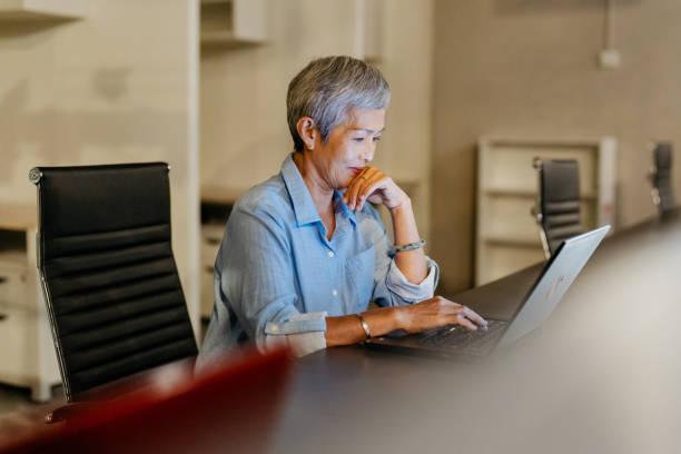 Senior Asian businesswoman working night shift in office