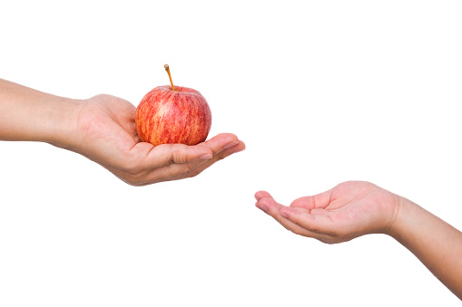 Woman giving apple to little girl from hand to hand on white background.