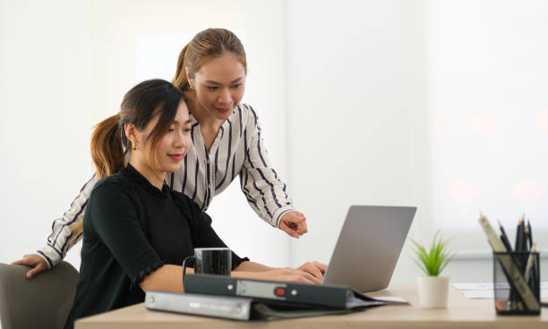 istock Two business women discussing business data with computer laptop at modern office. 1480704915