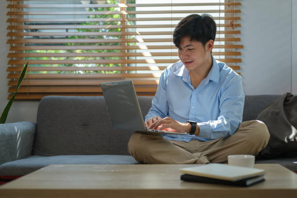 istock Man in casual clothes surfing internet, working online with laptop computer while sitting on couch at home. 1480704967
