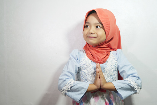 The expression of the girl who wears the hijab greeting happy Eid al-Fitr