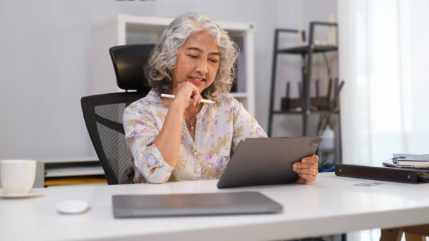 istock Happy senior woman looking at digital tablet, having online meeting, reading e book. 1480710131