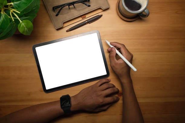 istock Above view of creative man hand holding stylus pen and using digital tablet on wooden working desk. 1480710153
