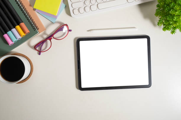 istock Flat lay, top view of digital tablet with empty screen, glasses and stationery on white table. 1480716095