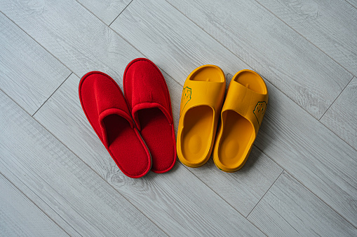 Slippers seen from above on white laminate parquet floor. Home sweet home.