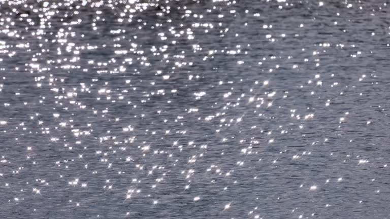 The surface of the water with waves that reflect the glittering light