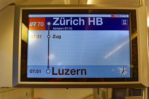 Inside train number IR 70 with screen showing destination of Zug and Luzern at main railway station of Zürich on a sunny spring day. Photo taken March 22nd, 2023, Zurich, Switzerland.