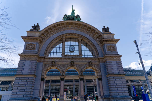 Sightseeing at City of Luzern with gate of former railway main station with arches and tourists on a sunny spring day. Photo taken March 22nd, 2023, Lucerne, Switzerland.