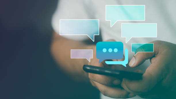 istock Text messages in cellphone screen with abstract hologram speech bubbles. Instant messaging app. 1480726686