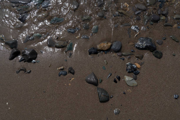 water surf, basalt stones and sand