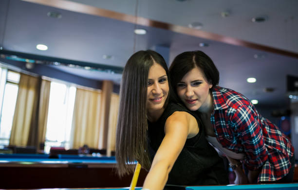 istock Smiling female friends playing pool together 1480728859