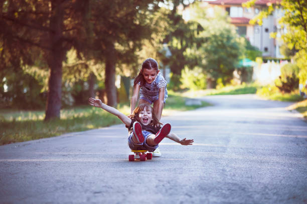 istock Happy kids with skateboards walking in a park 1480735216