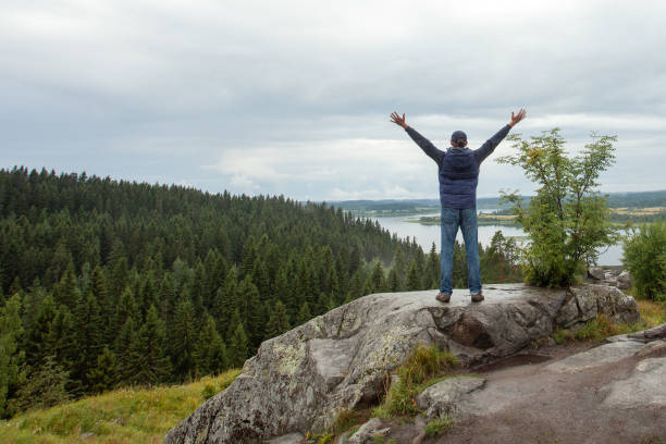 istock Man looking at the beautiful view with arms outstretched on mountain top 1480735316