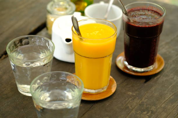 istock refreshing cold drinks. Mango juice, mulberry juice, water on a brown wooden table. refreshment drink. jus buah. assortment of juice. 1480737167