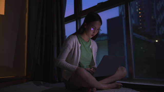 Businesswoman using laptop to work from home in the dark room