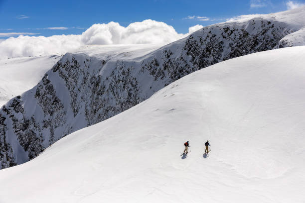 sciatori di fondo che scalano una pista all'inizio della primavera - rila mountains foto e immagini stock