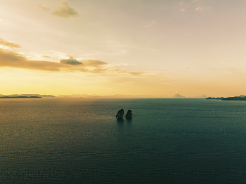 Koh Yao Yai Island Kissing Islands. Sunset over the Andaman Sea close to the Island of Koh Yao Yai, Two Karst Rock Fingers - called Kissing Islands - side by side under colourful moody sunset twilight. Aerial Drone Point of view flying over the Andaman Sea into the Sunset. Kissing Islands, Koh Yao Yai Island, Phuket Province, Thailand, Southeast Asia
