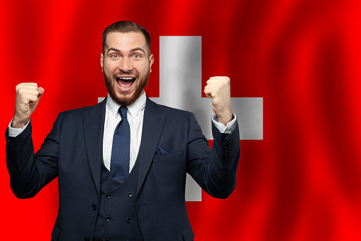 Swiss happy businessman on the background of flag of Switzerland Business, education, degree and citizenship concept