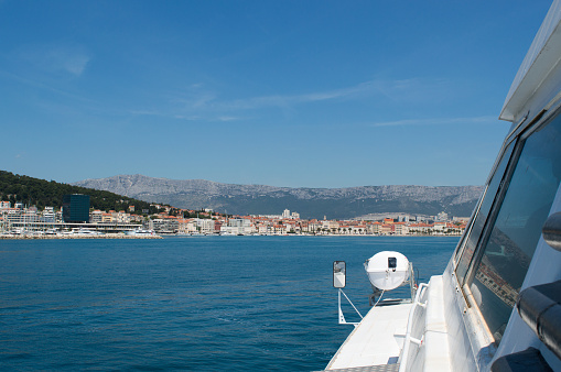 Male flip flops on a Boat pier in sea marina with city in background