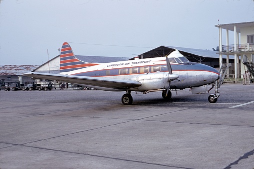 Douala, Cameroon, West Africa, 1967. Cameroon Air Transport aircraft at a Douala airfield. Also: ground staff and building.