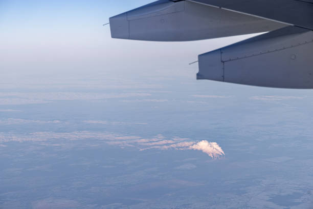 Photo with the view from the porthole of the airplane to the blue sky with white clouds at an altitude of about 10 kilometers
