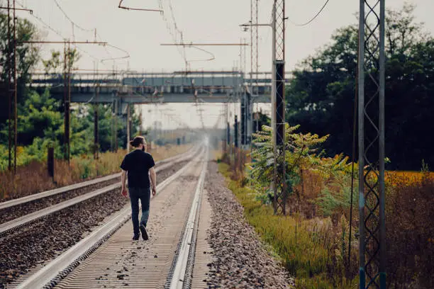 Young man walking on traintracks