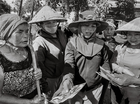 Five ethnic minority Jerai women in Ia Pia village, Chu Prong District, Gia Lai Province, Vietnam, look at old photographs together.