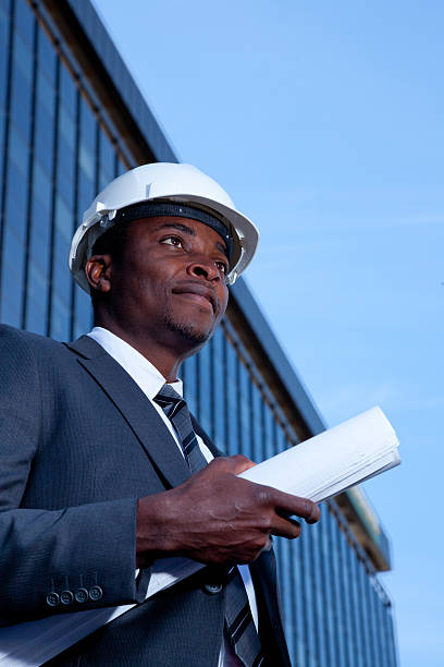 istock African man in hard hat holding building plans 148076719