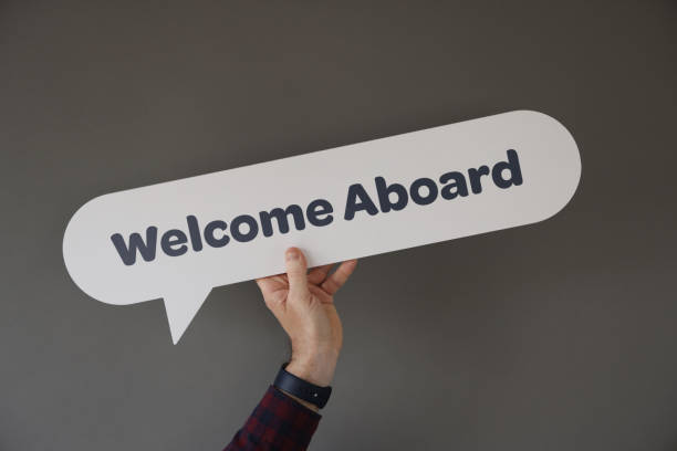 Hand holding the WELCOME ABOARD written speech bubble