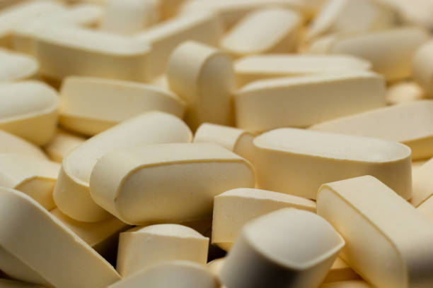 istock Macro Close up of white painkiller tablet on a reflective black background 1480776984