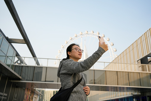 Asian women take photos while playing outdoors