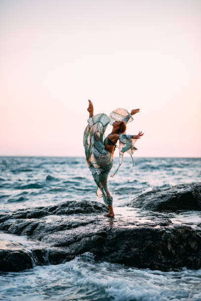 Woman Dancing on the Cliffs on the Beach at Sunset