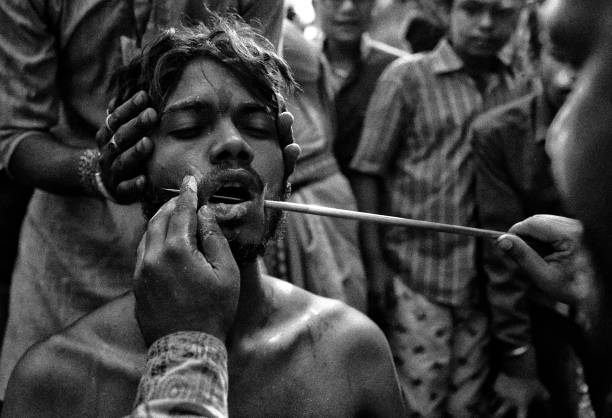 A devotee is seen getting pierced by a vel spear (also known as a divine javelin) during the Vel Vel religious festival in West Bengal. Velvel is a Hindu festival dedicated to the Hindu God Murugan / Mutthumariamman and is celebrated in the month of April. Devotees perform different painful rituals, often involving piercing, with a belief that God Murugan / Mutthumariamman will save their family members from all evil powers for next one year.