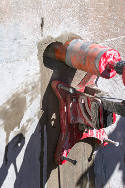 istock Worker is drilling to concrete wall with core drill machine. Core drills used in metal are called annular cutters. Core drills used for concrete and hard rock generally use industrial diamond grit. 1480787973