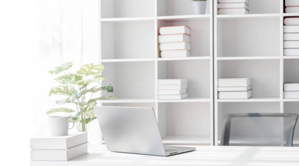 istock White creative workspace with open laptop computer on the table. Mock up workspace with laptop computer and book shelf. 1480788104