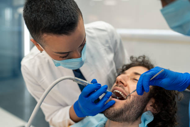 istock Female dentist specialist using dental drill working on patient's teeth 1480789430