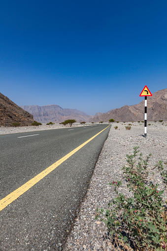 asphalt road and curve road sign in oman.