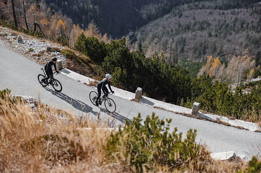 Confident professional cyclists on their road bikes, surrounded by the rugged beauty of nature.