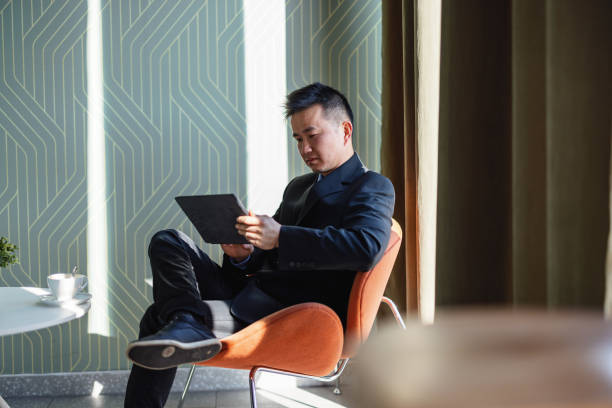 istock Chinese Businessman Sitting In A Restaurant While Drinking Coffee And Working 1480792907